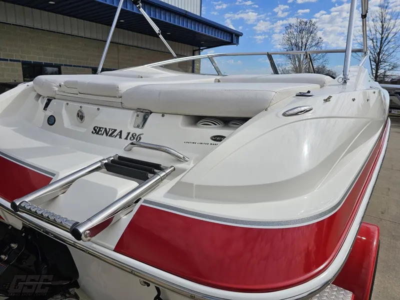 Slide: The Image of 2010 Larson Senza 186 boat with red and white exterior, docked outdoors. - 31