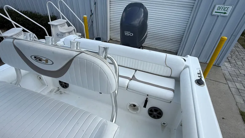 Slide: The Image of 2010 Sea Hunt Ultra 210 boat interior with Yamaha 150 engine, white seating, and storage compartments. - 11