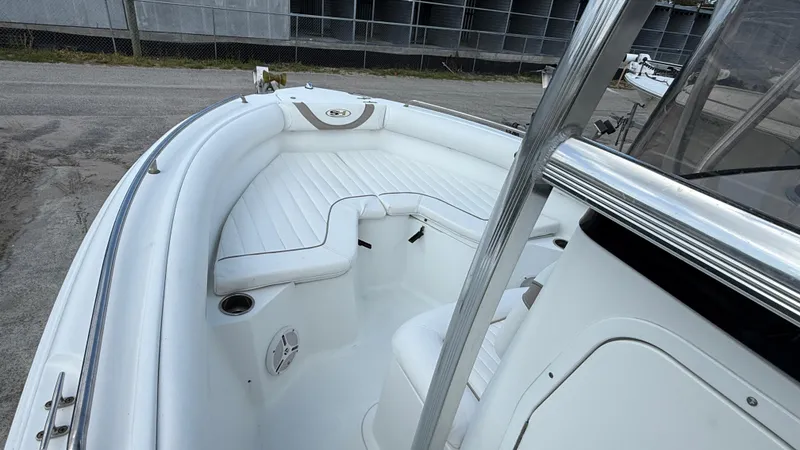 Slide: The Image of 2010 Sea Hunt Ultra 210 boat with white cushioned seating and cup holders. - 13