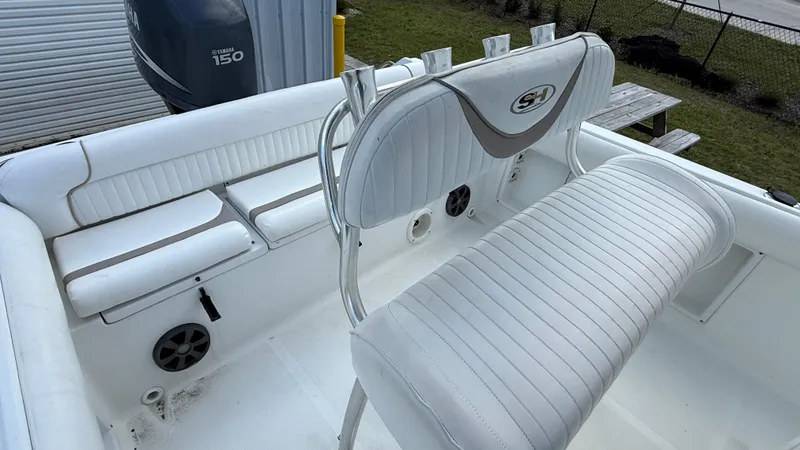 Slide: The Image of 2010 Sea Hunt Ultra 210 boat interior with white seating and Yamaha 150 engine. - 16