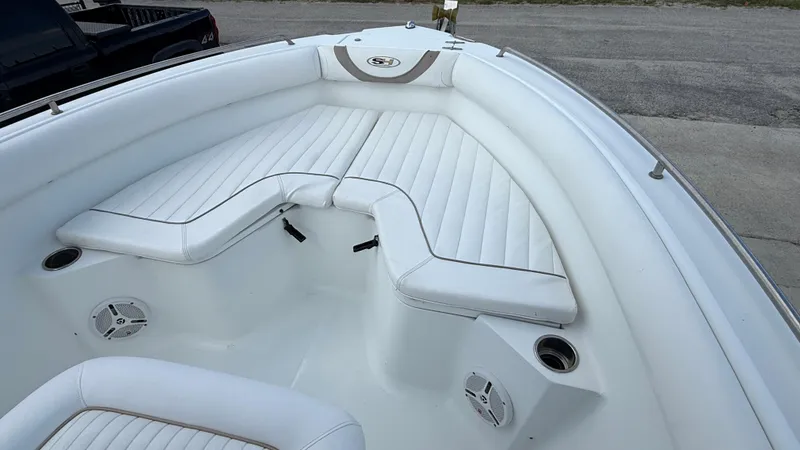 Slide: The Image of 2010 Sea Hunt Ultra 210 boat interior with white cushioned seating and cup holders. - 17