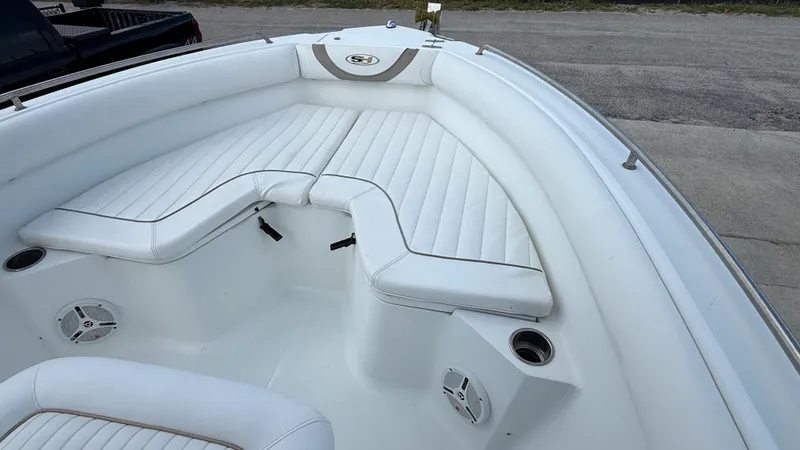 Slide: The Image of 2010 Sea Hunt Ultra 210 boat with white cushioned seating and cup holders. - 18