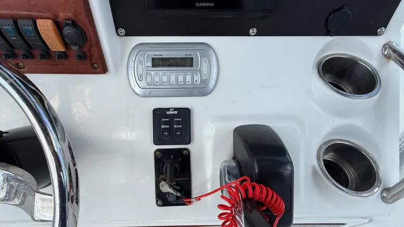 Slide: The Image of 2010 Sea Hunt Ultra 210 boat dashboard with controls and cup holders. - 19