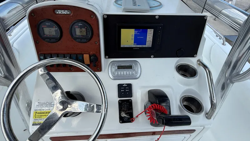Slide: The Image of 2010 Sea Hunt Ultra 210 boat dashboard with steering wheel and navigation instruments. - 22