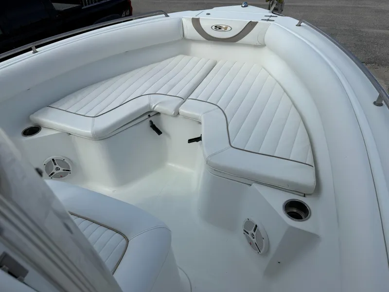 Slide: The Image of 2010 Sea Hunt Ultra 210 boat interior with white cushioned seating and cup holders. - 25