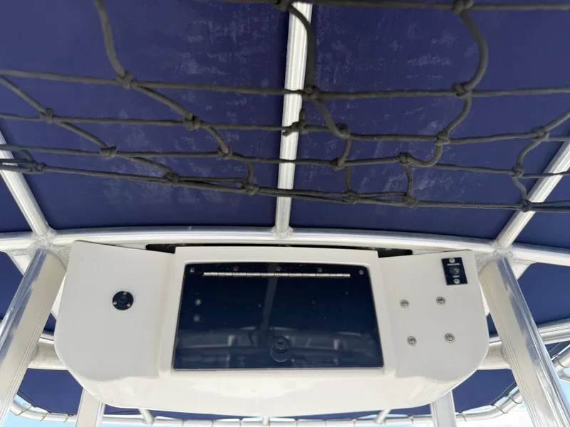 Slide: The Image of 2010 Sea Hunt Ultra 210 boat console with blue canopy and netting. - 29