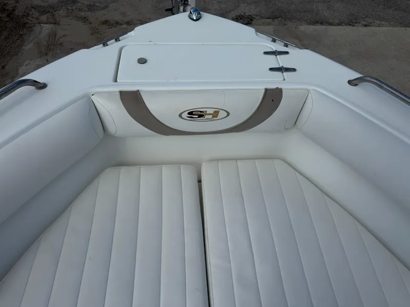 Slide: The Image of 2010 Sea Hunt Ultra 210 boat interior with white cushioned seating. - 34