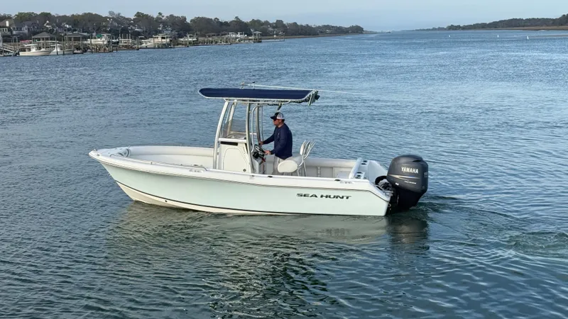 Slide: The Image of 2010 Sea Hunt Ultra 210 boat cruising on a calm waterway. - 4