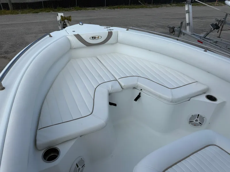 Slide: The Image of 2010 Sea Hunt Ultra 210 boat interior with white cushioned seating and cup holders. - 40