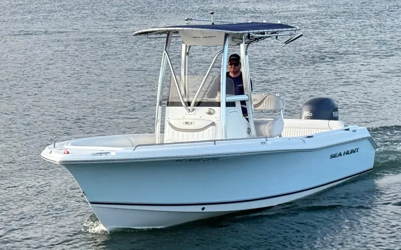 Slide: The Image of 2010 Sea Hunt Ultra 210 boat cruising on water with a person at the helm. - 49