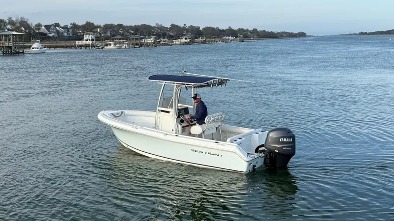Slide: The Image of 2010 Sea Hunt Ultra 210 boat on calm water with Yamaha outboard motor. - 6
