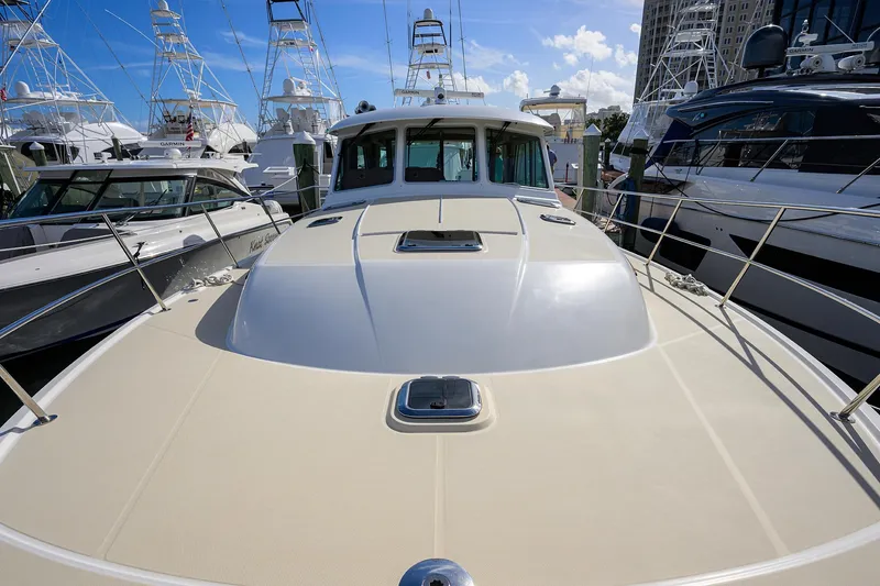 Slide: The Image of 2018 Sabre 48 Salon Express yacht docked among other boats under a clear blue sky. - 19