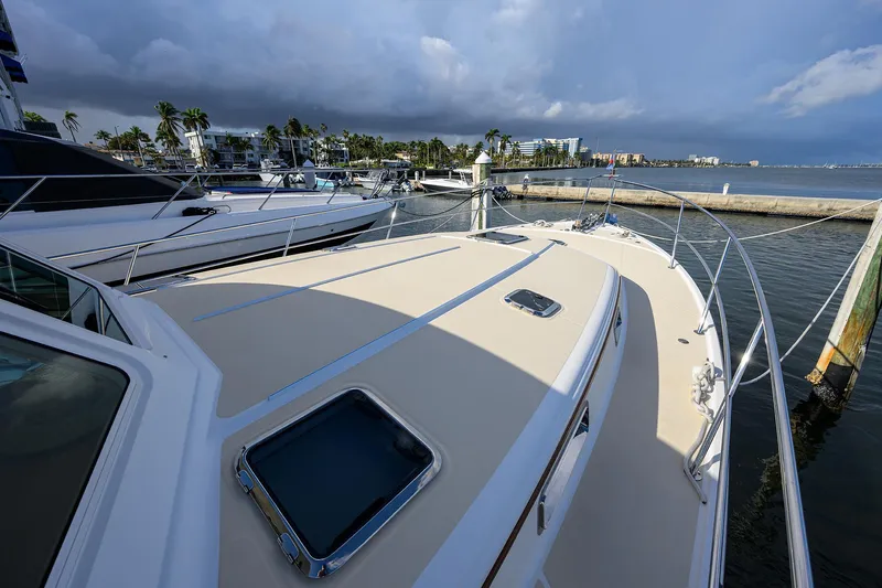 Slide: The Image of 2018 Sabre 48 Salon Express yacht docked at marina under cloudy sky. - 20