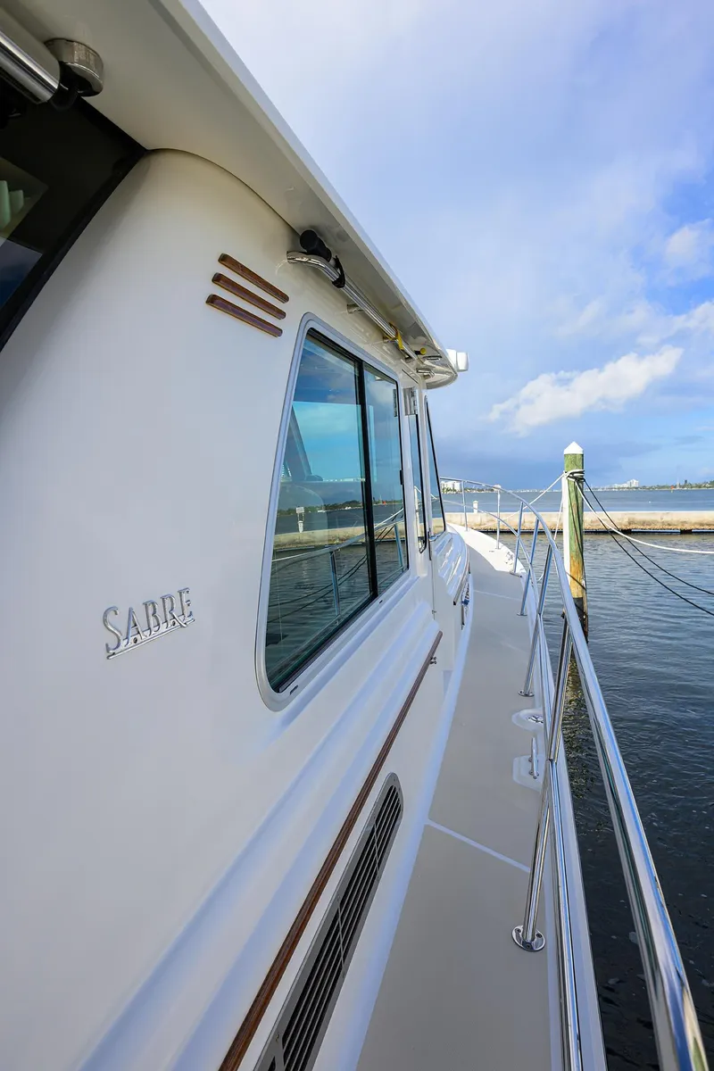 Slide: The Image of 2018 Sabre 48 Salon Express yacht docked, showcasing sleek design and ocean view. - 21