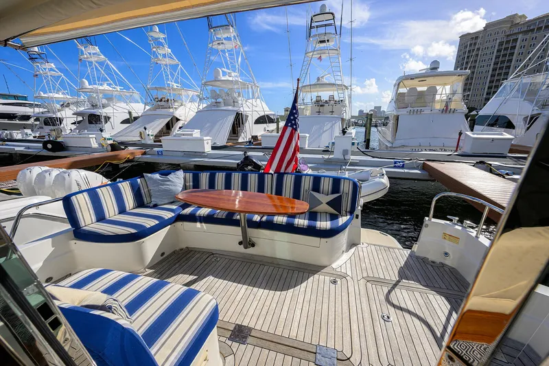 Slide: The Image of 2018 Sabre 48 Salon Express yacht with striped seating and American flag at marina. - 22