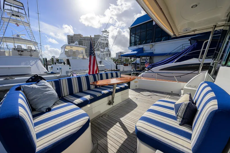 Slide: The Image of 2018 Sabre 48 Salon Express yacht with striped seating and American flag in marina. - 23