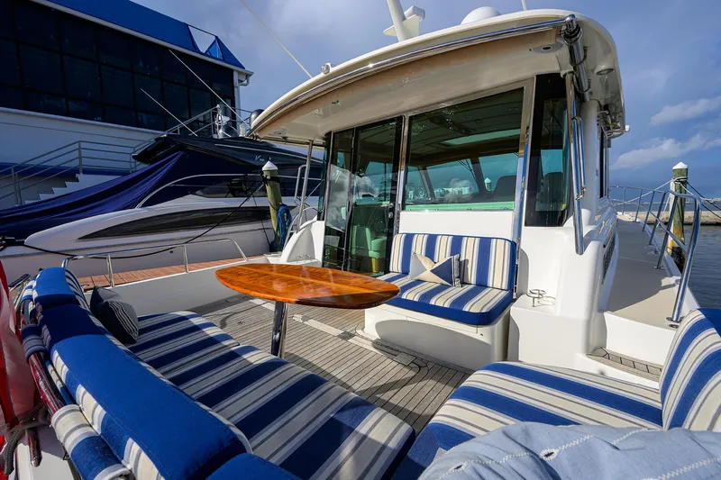 Slide: The Image of 2018 Sabre 48 Salon Express yacht with striped seating and wooden table on deck. - 24