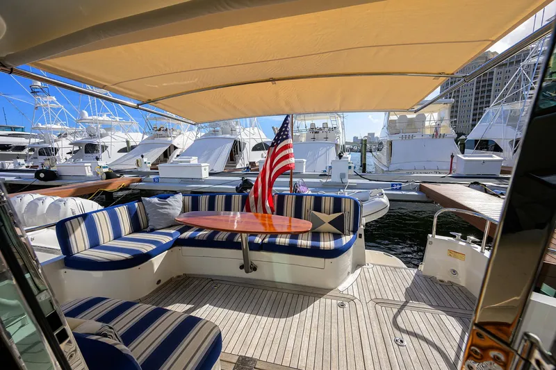 Slide: The Image of 2018 Sabre 48 Salon Express yacht with striped seating and American flag at marina. - 27