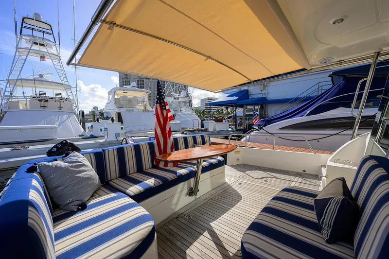 Slide: The Image of 2018 Sabre 48 Salon Express yacht with striped seating and American flag at marina. - 28