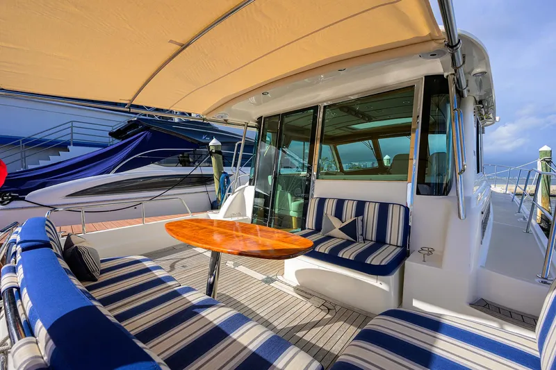 Slide: The Image of 2018 Sabre 48 Salon Express yacht with striped seating and wooden table on deck. - 29