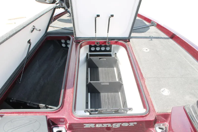 Slide: The Image of 2015 Ranger Z518C Comanche boat storage compartments, open and empty, showcasing interior design. - 15