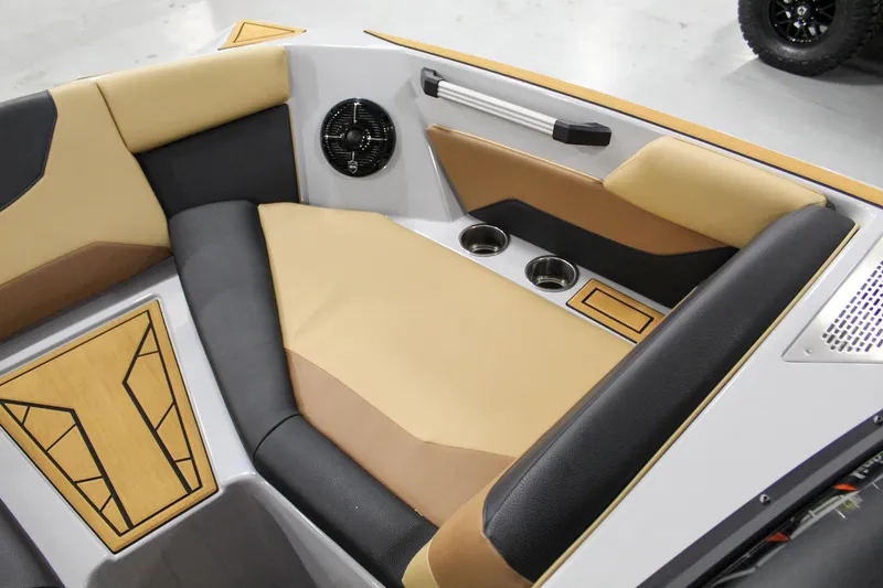 Slide: The Image of 2025 ATX Surf Boats 20 Type-S interior with tan and black seating, cup holders, and speaker. - 12