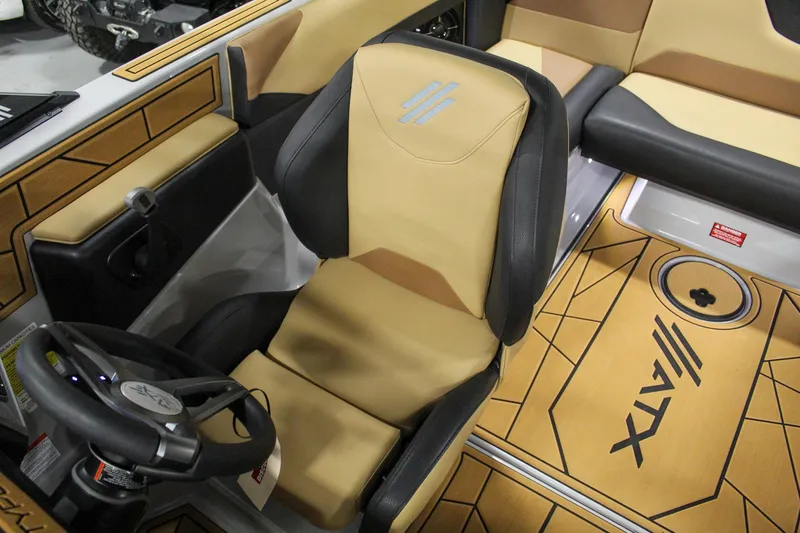 Slide: The Image of 2025 ATX Surf Boats 20 Type-S interior with tan and black seating, steering wheel, and logo. - 18