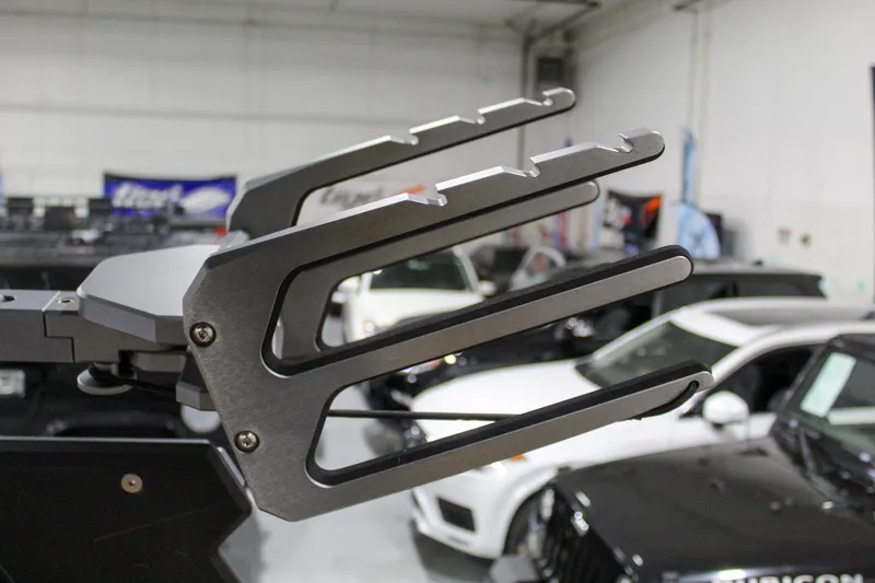 Slide: The Image of ATX Surf Boats 2025 20 Type-S wakeboard rack in showroom with cars in background. - 30