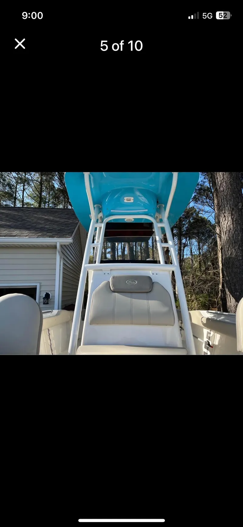 Slide: The Image of 2022 Key West 219 FS boat with blue canopy and seating, parked outdoors. - 5