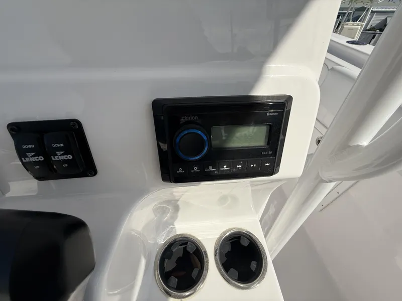 Slide: The Image of 2024 Aquasport 2500 CC boat console with Clarion audio system and Lenco controls. - 11