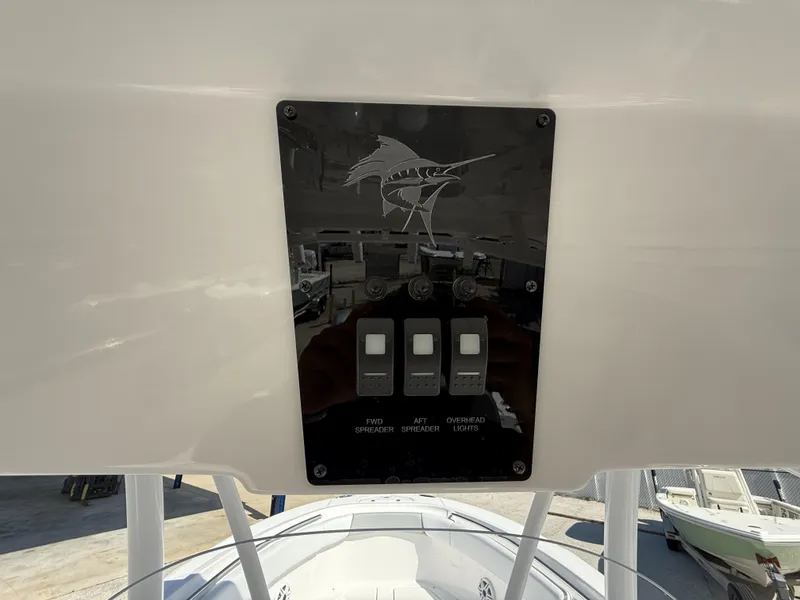 Slide: The Image of Control panel on 2024 Aquasport 2500 CC boat with switches and marlin design. - 12