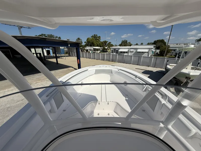 Slide: The Image of 2024 Aquasport 2500 CC boat deck view at a marina under clear skies. - 13