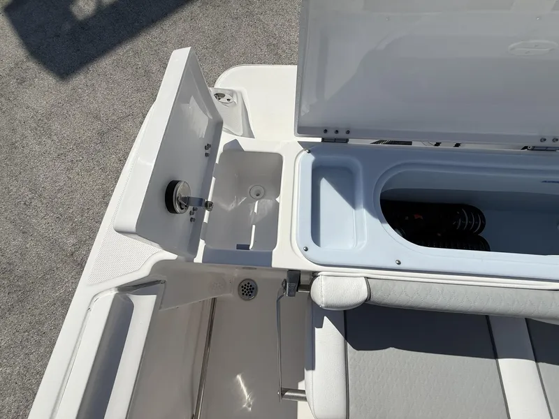 Slide: The Image of 2024 Aquasport 2500 CC boat interior with open storage compartments and seating. - 17