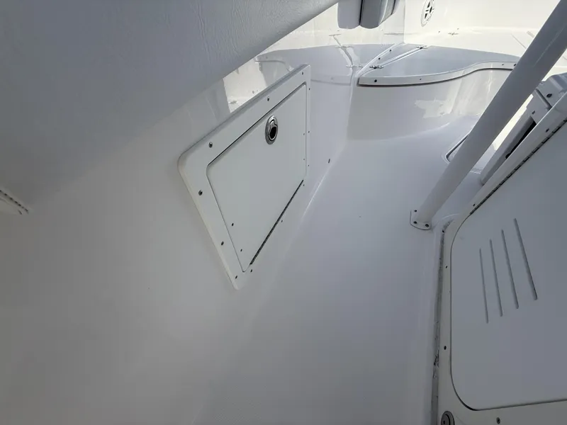 Slide: The Image of 2024 Aquasport 2500 CC boat interior, featuring sleek white storage compartment and seating area. - 20
