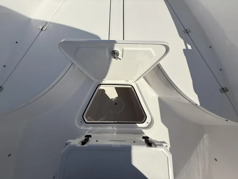 Slide: The Image of Open storage compartment on 2024 Aquasport 2500 CC boat deck. - 22