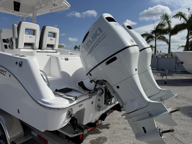 Slide: The Image of 2024 Aquasport 2500 CC boat with dual Suzuki outboard motors, parked near palm trees. - 25