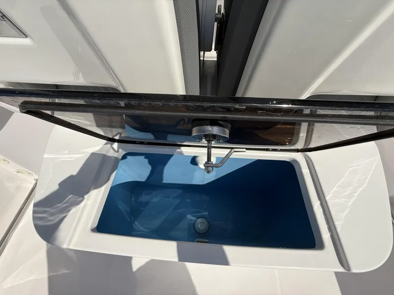 Slide: The Image of Livewell compartment on 2024 Aquasport 2500 CC boat, featuring a blue interior. - 36
