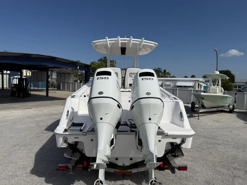 Slide: The Image of 2024 Aquasport 2500 CC boat with dual 150 horsepower engines, parked outdoors. - 4