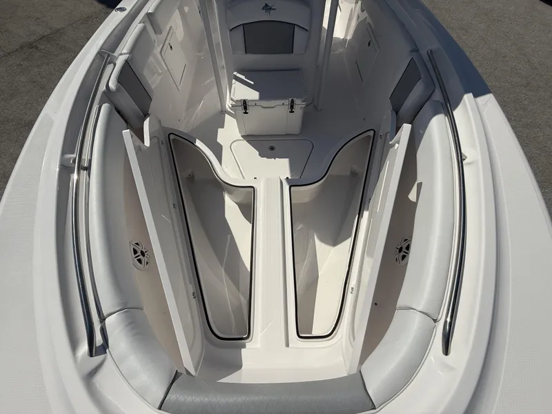 Slide: The Image of 2024 Aquasport 2500 CC boat interior with open storage compartments and cushioned seating. - 40