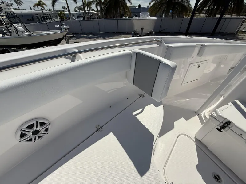 Slide: The Image of 2024 Aquasport 2500 CC boat interior with seating and speaker, docked under palm trees. - 41