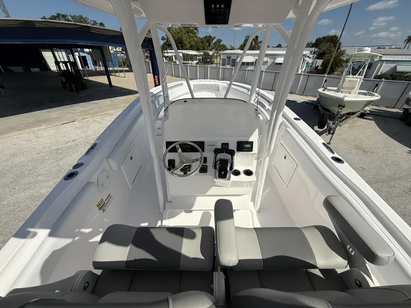 Slide: The Image of 2024 Aquasport 2500 CC boat interior with steering console and seating. - 9