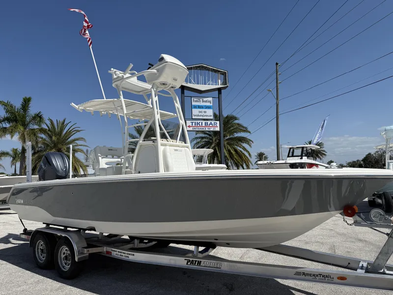 Slide: The Image of 2025 Pathfinder 2400 Open boat on trailer, displayed outdoors with palm trees and clear sky. - 1