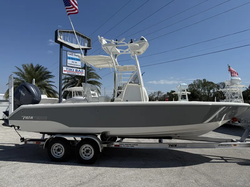 Slide: The Image of 2025 Pathfinder 2400 Open boat on trailer, displayed outdoors with American flags. - 23
