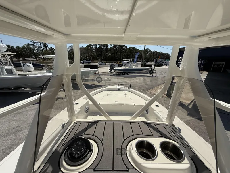 Slide: The Image of 2025 Pathfinder 2400 Open boat interior with console and cup holders, docked outdoors. - 9