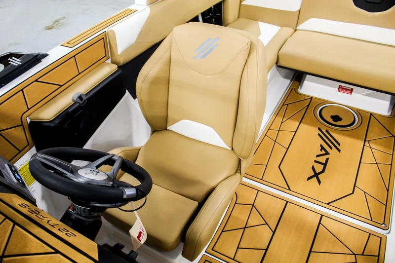 Slide: The Image of 2025 ATX Surf Boats 22 Type-S interior with tan seating and steering wheel. - 17