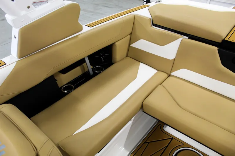 Slide: The Image of 2025 ATX Surf Boats 22 Type-S interior with tan and white seating, cup holders, and sleek design. - 21