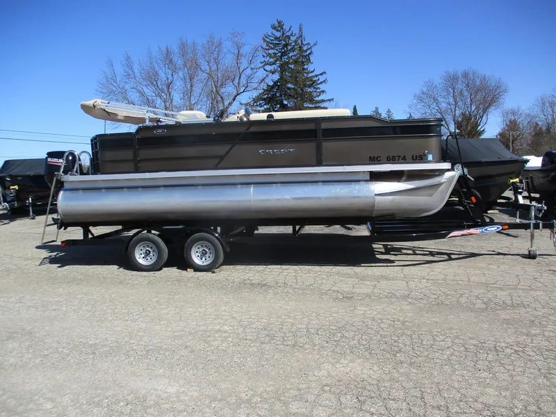 Slide: The Image of 2019 Crest FISH 200 C4 pontoon boat on a trailer, parked outdoors. - 1