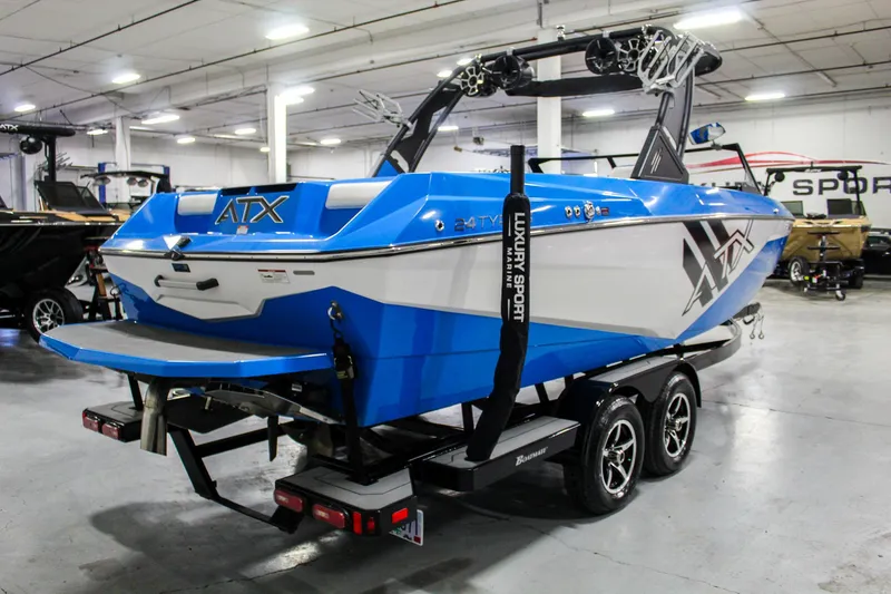 Slide: The Image of 2020 ATX Surf Boats 24 Type-S in showroom, blue and white design, on trailer. - 5