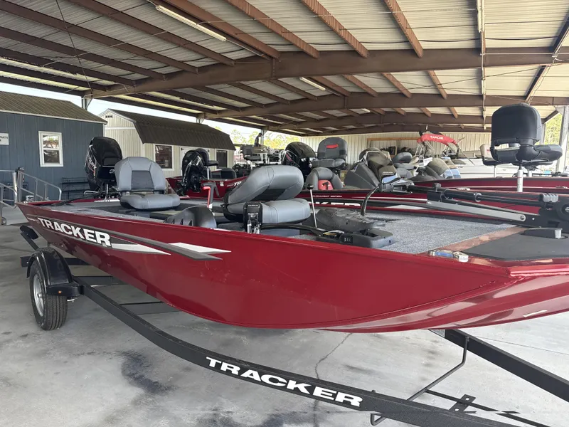 Slide: The Image of 2025 Tracker Panfish 17 boat in a covered storage area, featuring a sleek red design. - 6