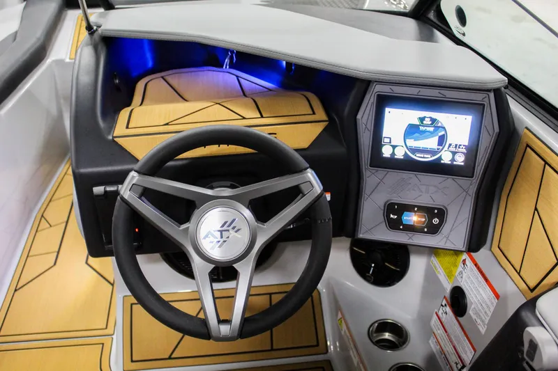 Slide: The Image of 2025 ATX Surf Boats 24 Type-S dashboard with steering wheel and touchscreen display. - 14
